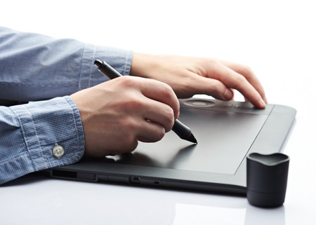 Closeup of digital tablet isolated on white background. Man doing sketch on digital tablet close-upの写真素材