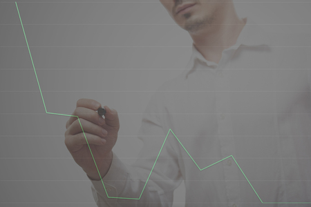 Man drawing graphic line on whiteboard office. Man draw chart tableの写真素材