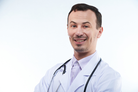 Young man doctor with stethoscope and crossed arms isolated on white backgroundの写真素材