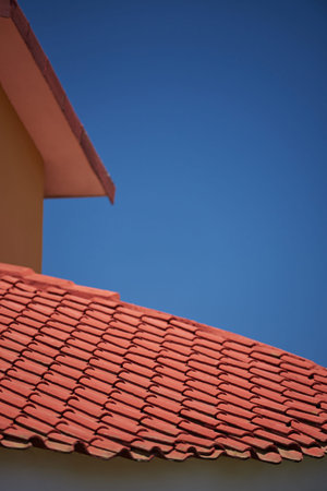 Red clay house roof tiles on blue sky backgroundの写真素材