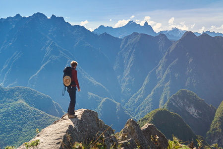 Man walking on mountain peak in summer sunny bright dayの写真素材