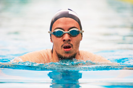 Close-up portrait of swimmer man swimming in pool