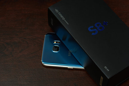New york, USA - June 12, 2017: Unboxing samsung s8 plus on dark wooden background