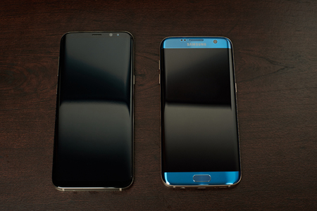 New york, USA - June 13, 2017: Samsung s8 plus and s7 edge smartphone lay on wooden background. Compare Samsung S8 and s7 edge phonesのeditorial素材