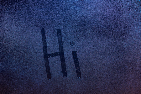 Hi word draw on wet window glass. Hi message on frozen window backgroundの写真素材