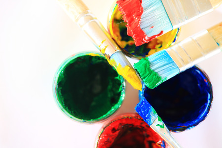 Colorful art background. Brushes with paint on paint boxes close-up.の写真素材