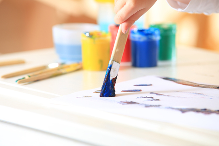 Brush in blue paint on colorful paint box background. Children's creativity background.の写真素材