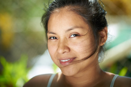 Brunette girl with hair on face close-up portraitの写真素材
