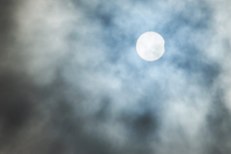 Real solar eclipse background on cloudy sky