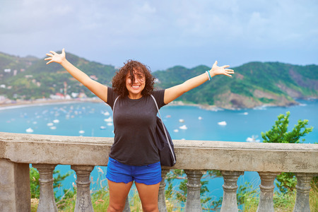 Young woman with hands up on vacation in travel destinationの写真素材