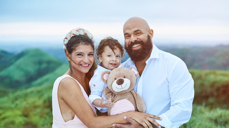 Smiling young latino family on natural blurred backgroundの写真素材