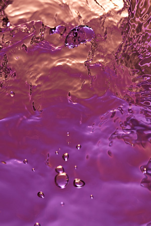 Abstract water drops and bubbles on red and purple liquid textureの写真素材