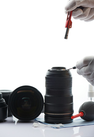 Professional maintenance of dslr lens in white lab desk. Closeup of fixing photography equipmentの写真素材
