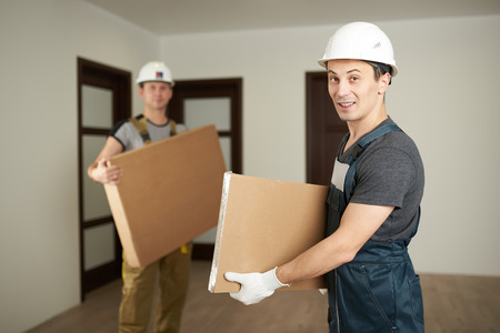 Delivery parcel concept. Two man hold cardboard boxesの写真素材