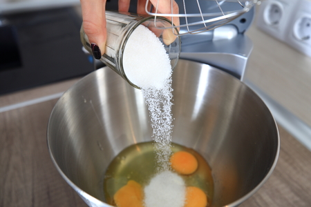 Baker adds sugar in bowl close-up. Baker cooks pie professionally.の写真素材