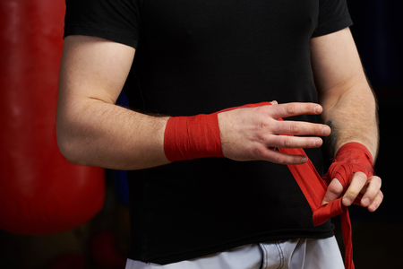 Caucasian man apply hand bandage close up view. Sportman before fightの写真素材