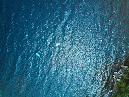 Two colorful kayak in blue lagoon water above aerial viewの写真素材