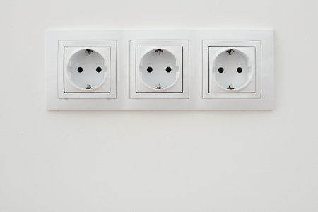 Three electrical socket on white wall close up viewの写真素材