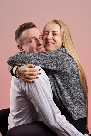 Caucasian couple in love hug isolated on pink backgroundの写真素材