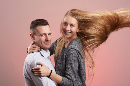 Happy smiling caucasian couple hugging isolated on pink backgroundの写真素材