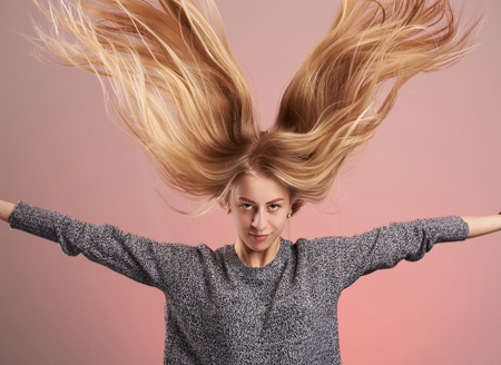 Young blonde woman with hair up isolated on pink backgroundの写真素材