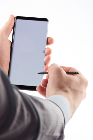 Using smartphone with pen touch isolated on white backgroundの写真素材