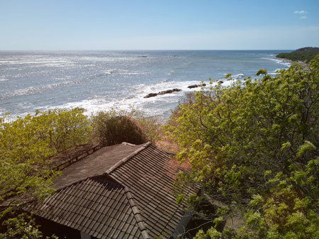 Sunny eco vacation on beach. House roof on beach background