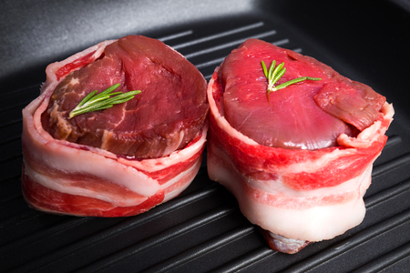 Filet mignon wrapped in fresh bacon on pan close-up. Fresh raw beef meat.の写真素材