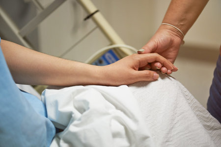 Medical support theme. Close up of patient hand holding relative hand