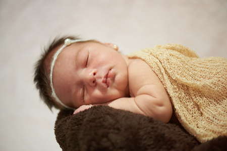 Newborn baby taking nap close up view on bright backgroundの写真素材