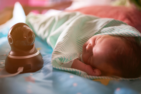 Monitoring sleeping baby with dome camera close-up viewの写真素材