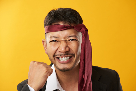 Portrait of happy asian young man isolated on yellow backgroundの写真素材