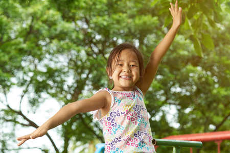 Happy smiling asian girl on outside sunny park backgroundの写真素材