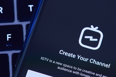 New york, USA - July 6, 2018: Creating IGTV channel in instagram with smartphone screen lay on laptop keyboardのeditorial素材