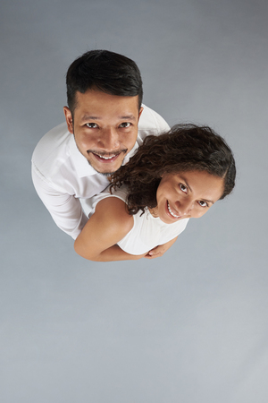 Young hugging couple isolated on gray background above top viewの写真素材