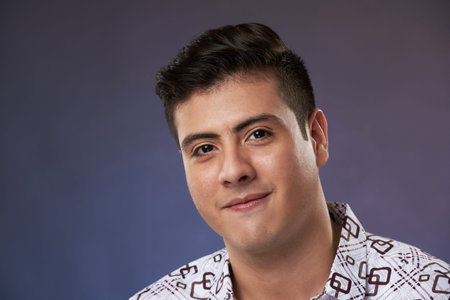 Serious young man portrait on dark blue studio background
