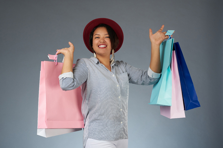 Shopping sale theme. Young smiling woman with colorful bagsの写真素材