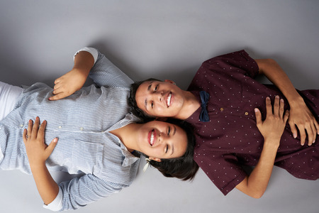 Happy smiling young couple lying next to each other above top viewの写真素材