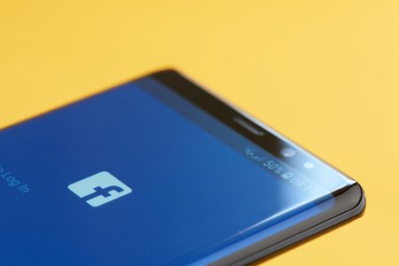 New york, USA - october 3, 2018: Facebook app on smartphone screen close up view with yellow backgroundのeditorial素材