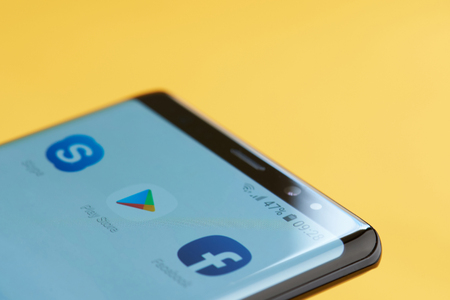 New york, USA - october 3, 2018: Play store icon on smartphone screen close up view with yellow backgroundのeditorial素材