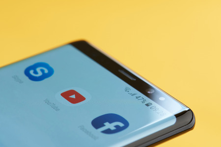 New york, USA - october 3, 2018: Youtube icon on smartphone screen close up view with yellow backgroundのeditorial素材