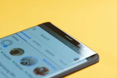 New york, USA - october 3, 2018: Facebook messenger app on smartphone screen close up view with yellow backgroundのeditorial素材