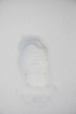 One footprint on snow background. Human shoe trace on snowの写真素材