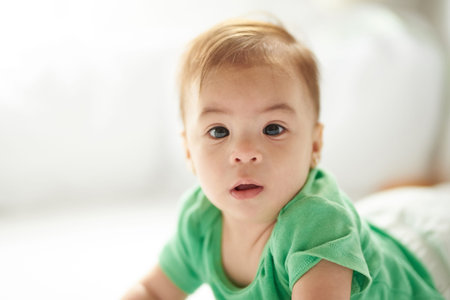 Close-up portrait of baby girl on white bed backgroundの写真素材