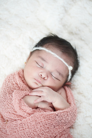 Newborn sleeping above top view on soft white backgroundの写真素材