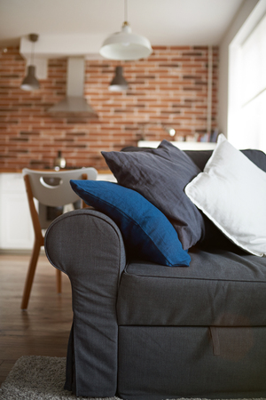 Gray sofa with pillows close up in aparment roomの写真素材