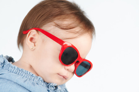 Looking down baby in sunglasses isolated on white backgroundの写真素材
