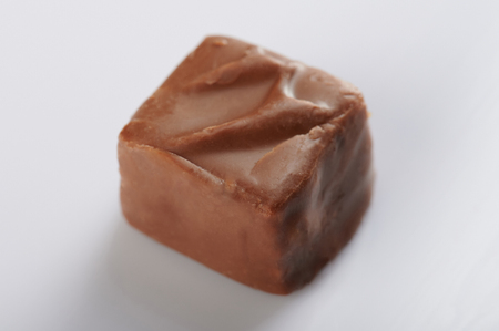 One piece of sweet chocolate with caramel candy bar isolatedの写真素材