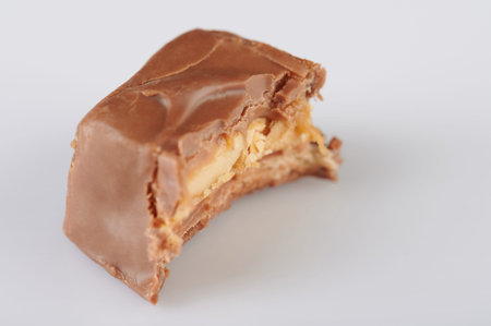 Piece of chocolate candy bar bite isolated on white backgroundの写真素材