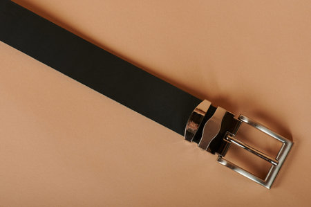 Black leather narrow belt on beige color background